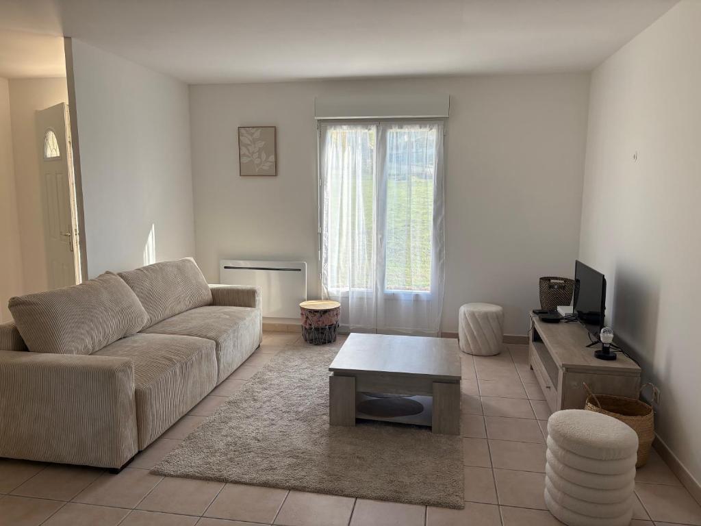 a living room with a couch and a coffee table at La petite maison in Buchey