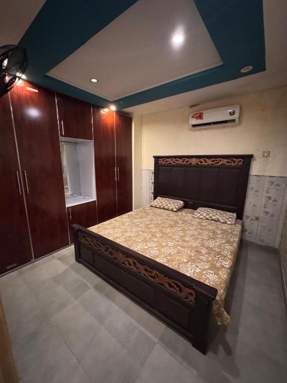 a bedroom with a large bed and wooden cabinets at Jd apartment in Kariāla Railroad Station