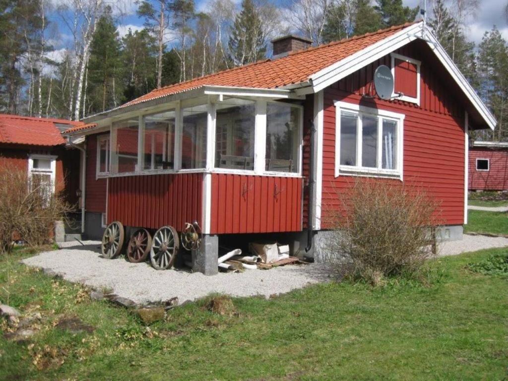 a red house with wheels in front of it at Mormors hus in Jörlanda