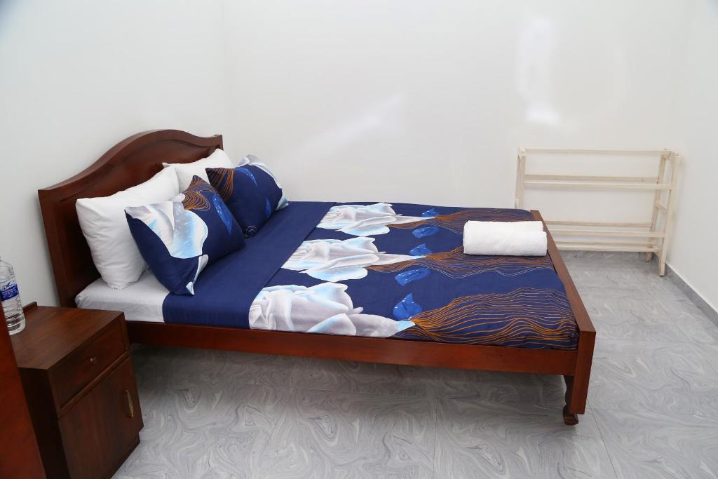 a bed with blue and white sheets and pillows at Tropical apartment no 7 in Nugegoda