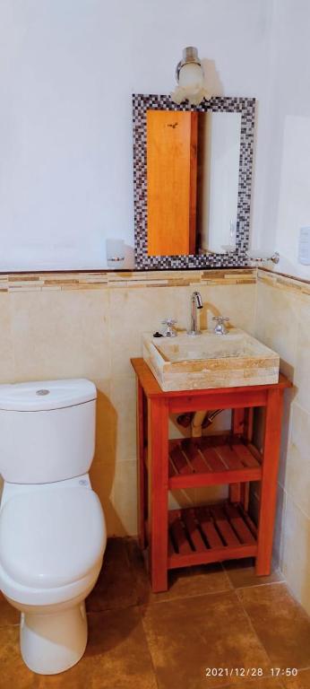 a bathroom with a toilet and a sink and a mirror at CASA TEMPORADA 2027 PARQUEMAr in Miramar