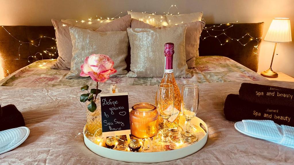 ヴァルナ・シティにあるSea Sky Houseのベッドの上にワイン1本とグラス1杯