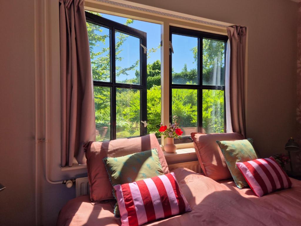 a bedroom with a bed and a large window at Vakantiehuis Joghmanstuin in Kapel-Avezaath
