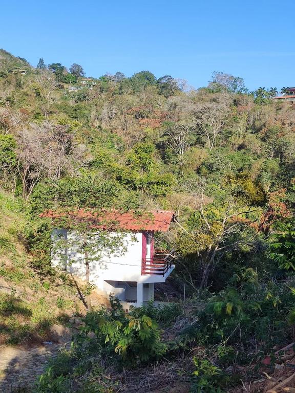 a small house on the side of a hill at Chalé Bella Vista in Mulungu