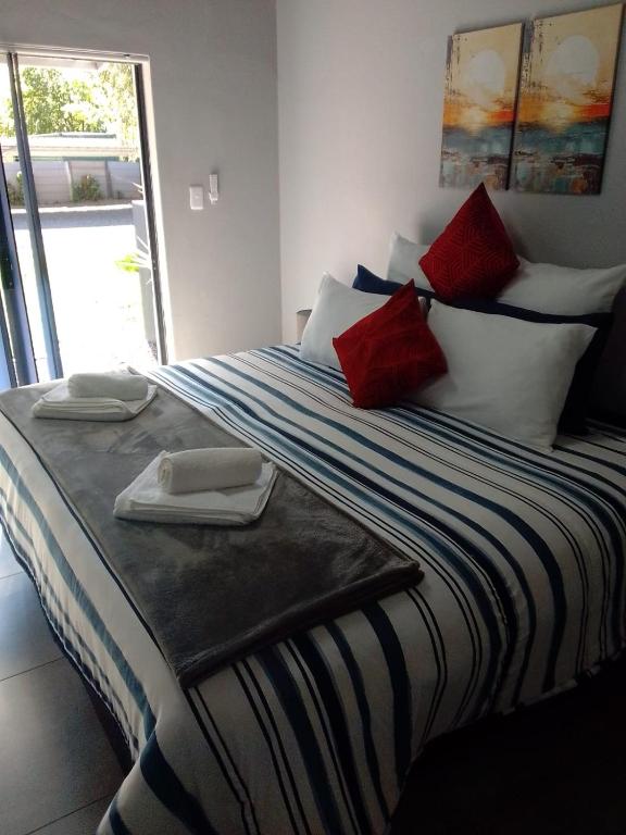 a bedroom with a bed with red and white pillows at Columbae Guesthouse in Parys