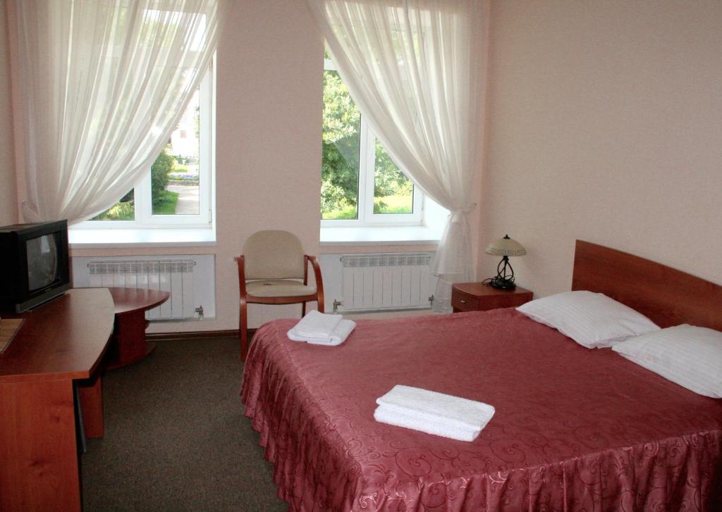 Danilov的住宿－Hotel Sot，一间卧室配有红色的床和2条毛巾