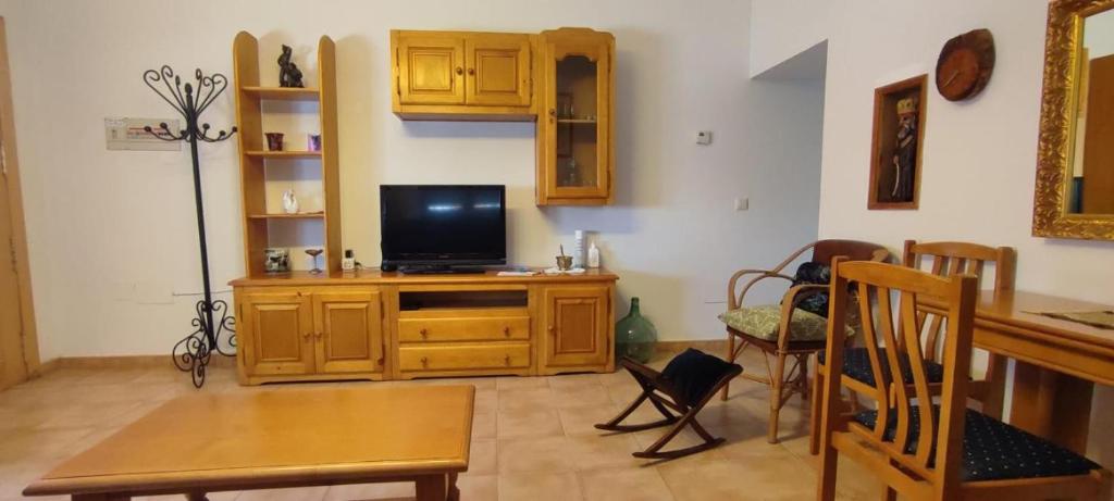 un soggiorno con TV su un centro di intrattenimento in legno di Casa De Los Abuelos a Ortigosa del Monte