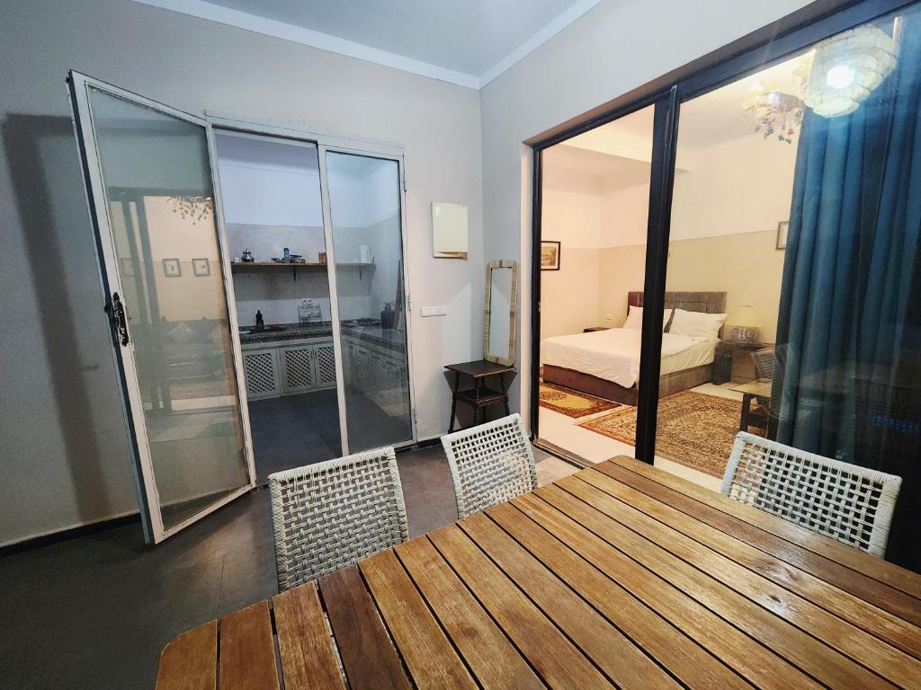 a room with a table and chairs and a bedroom at Douiria salix agafay in Marrakech