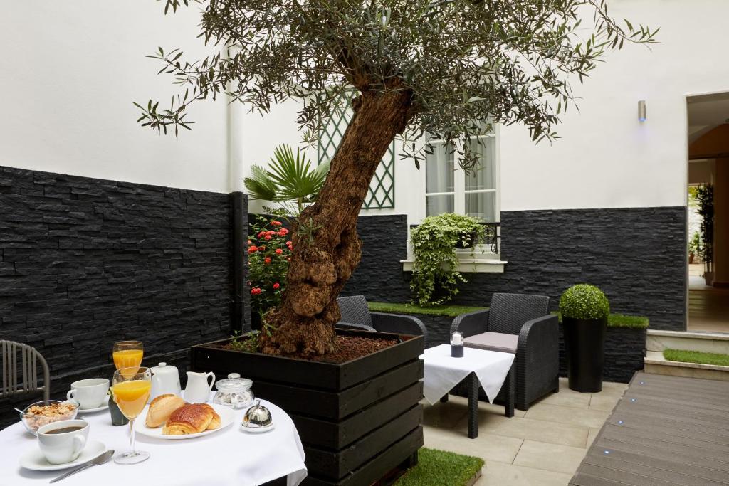 een tafel met eten en drinken en een boom bij Hotel Le Twelve in Parijs