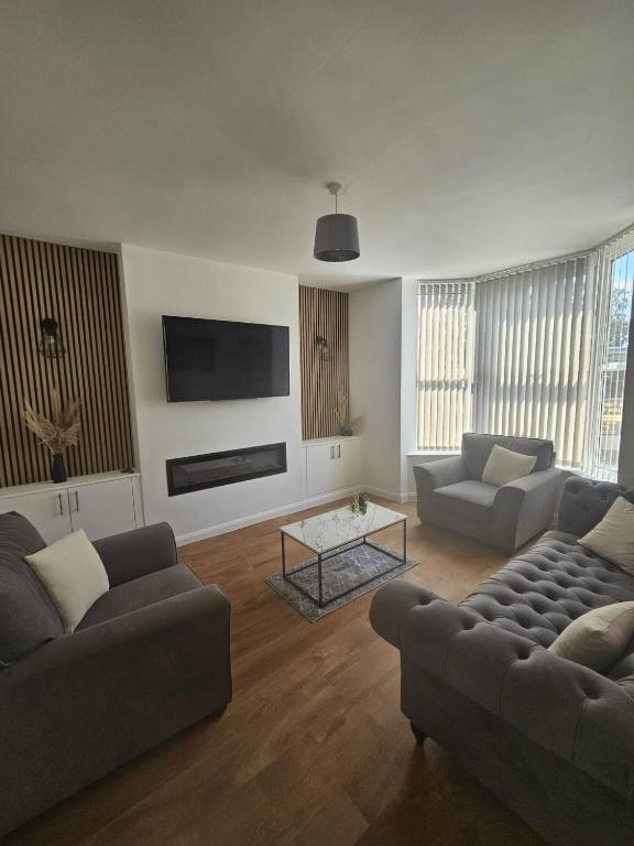 a living room with two couches and a tv at Spacious House with Parking and pool table in Kirton