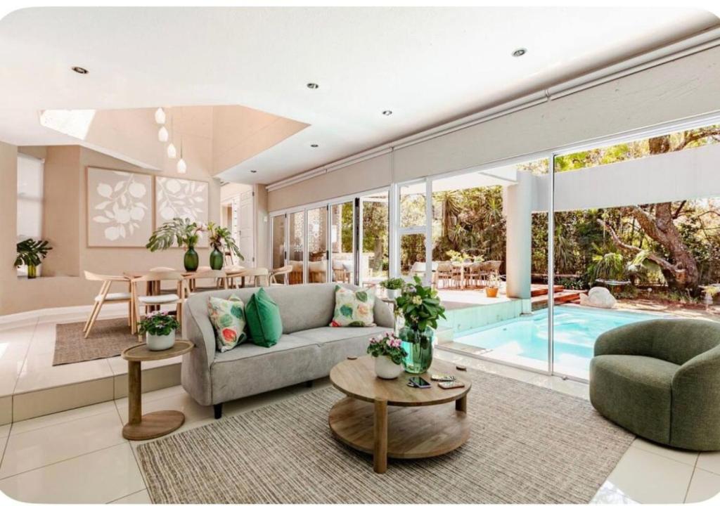 sala de estar con sofá y piscina en Wellness Guesthouse, en Krugersdorp