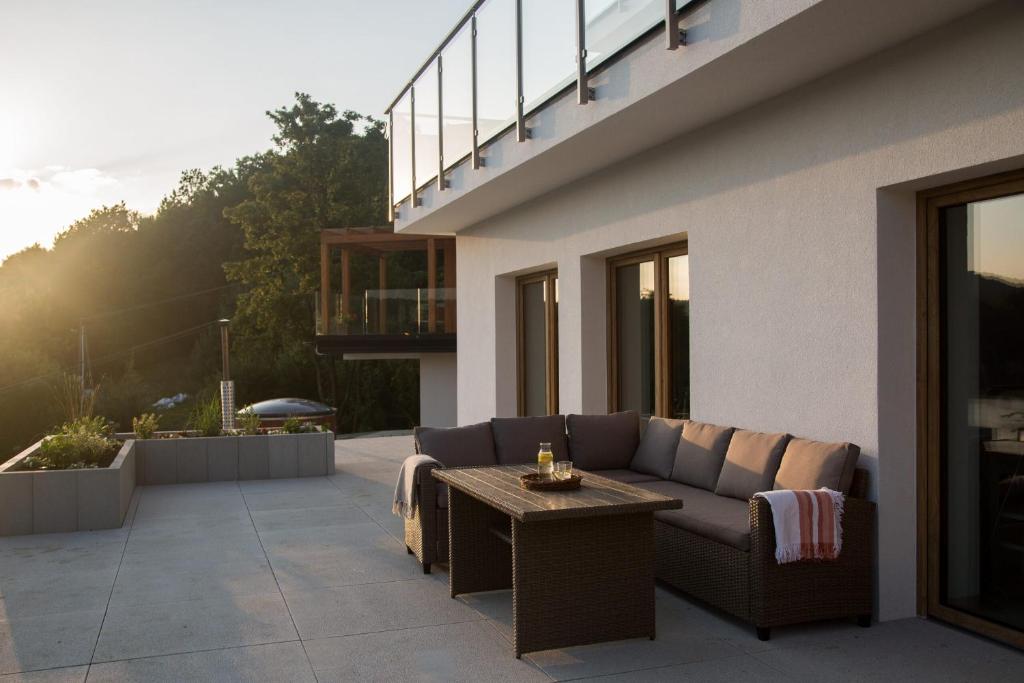 un patio con sofá y mesa en un edificio en Nad Jeziorem, en Rożnów