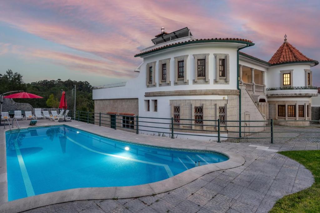a large house with a swimming pool in front of it at Calejo House – Pool & Sports & Grill Retreat in Nogueira