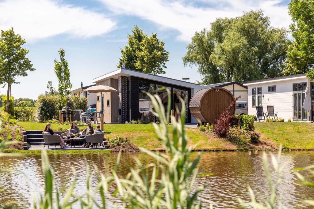 a group of people sitting around a table by a pond at Recreatiepark het Esmeer in Aalst