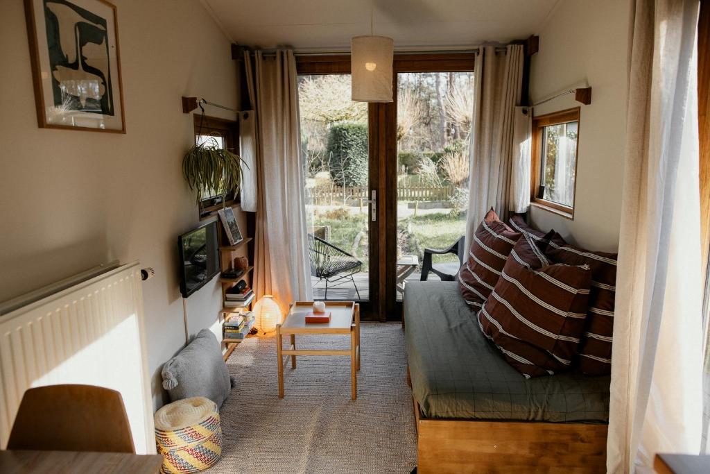 a living room with a couch and a table at Tiny House Alba - ervaar tiny house living in Diessen