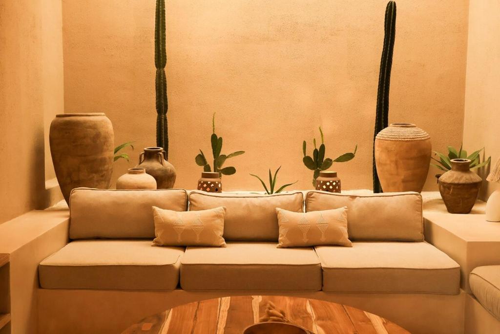 a living room with a couch and some potted plants at Pasir 3 - A stylish 2 bed villa in Bingin w pool in Bingin Beach