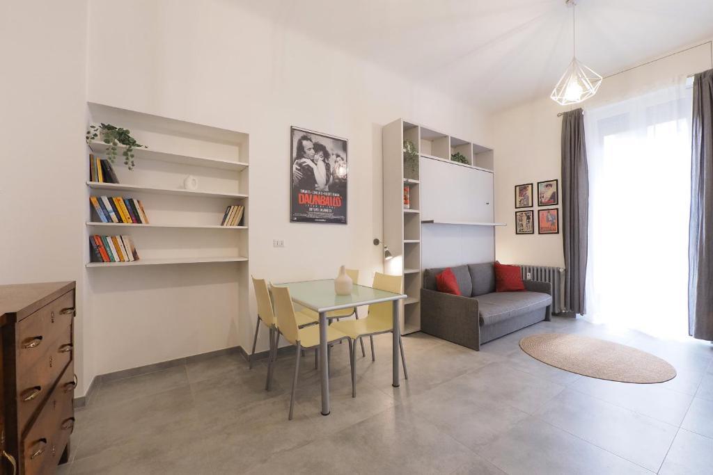 a living room with a table and a couch at PrimoPiano - Sempione in Milan