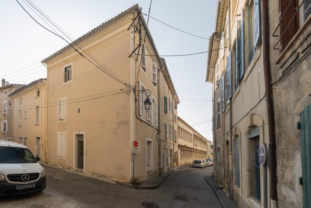 Une allée dans une vieille ville avec des voitures garées dans l'établissement Bâtiment Les Iris, à Bourg-Saint-Andéol