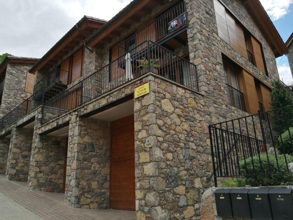 un edificio de piedra con balcón en la parte superior. en Apartament Torrent de la Barruda, en Vilallonga de Ter