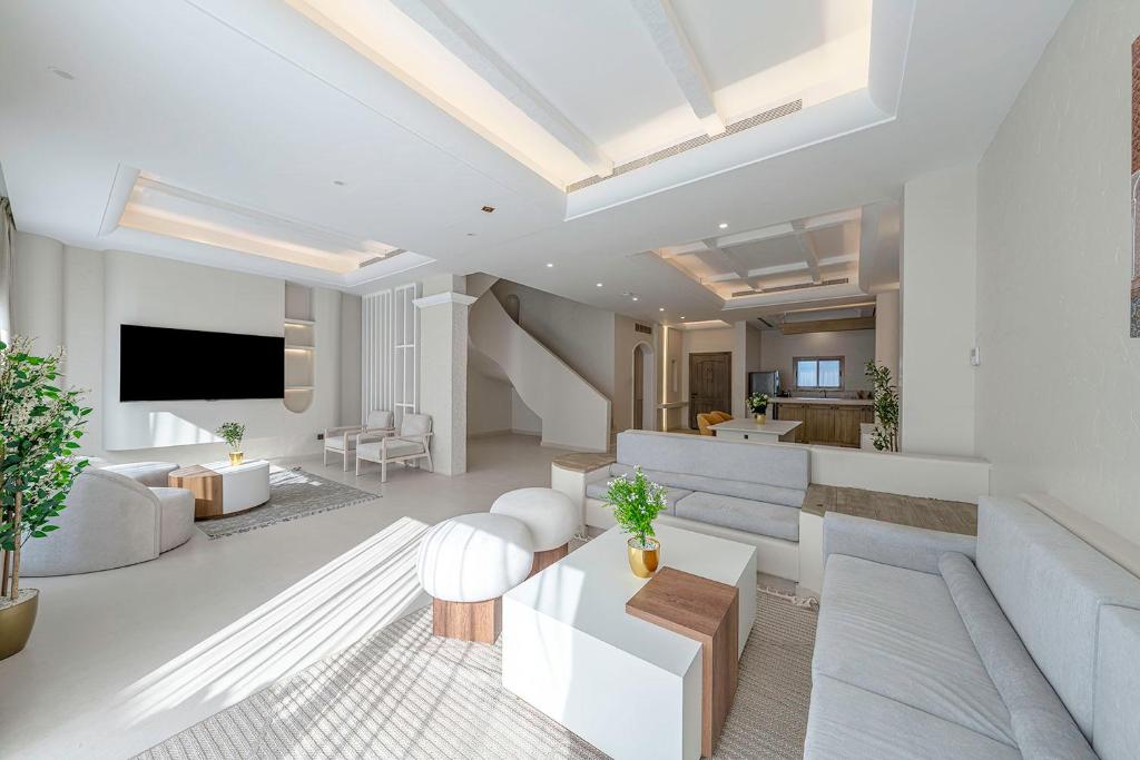 ein Wohnzimmer mit weißen Möbeln und einem Flachbild-TV in der Unterkunft Mabaat-Jasmine Greek Villa 4BR- 583 Villa 13 in Dschidda