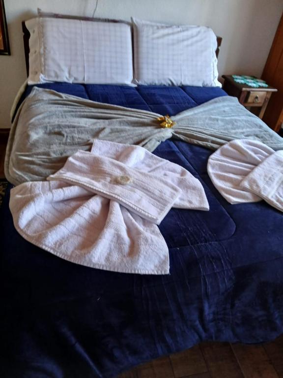 a bed with two towels on top of it at Pousada dos Pássaros in Camanducaia