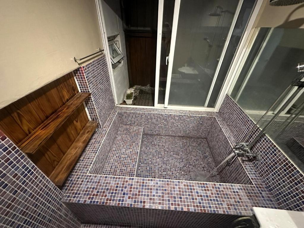 baño con ducha y suelo de baldosa. en The best hot spring room in town, en Hengchun