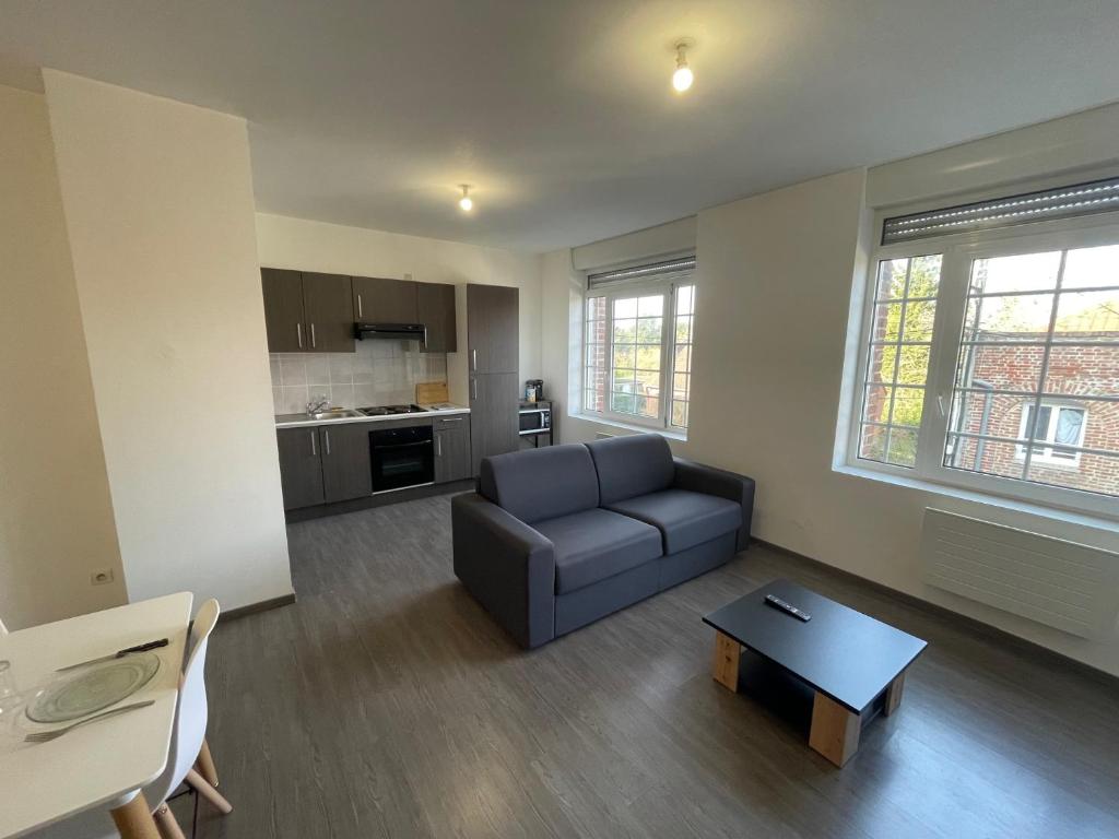 a living room with a couch and a table at Business Apparts Caudry in Caudry