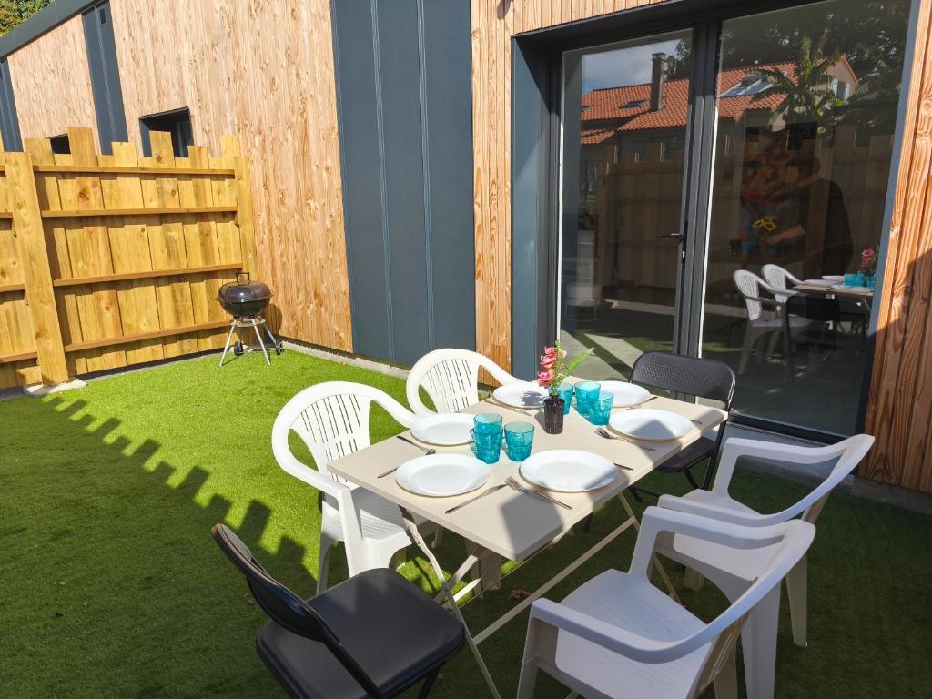 a white table and chairs on a patio at Gîtes Néphélie votre cocon tout confort aux portes du Puy duFou - Climatisé, Terrasse, Parking in Les Épesses
