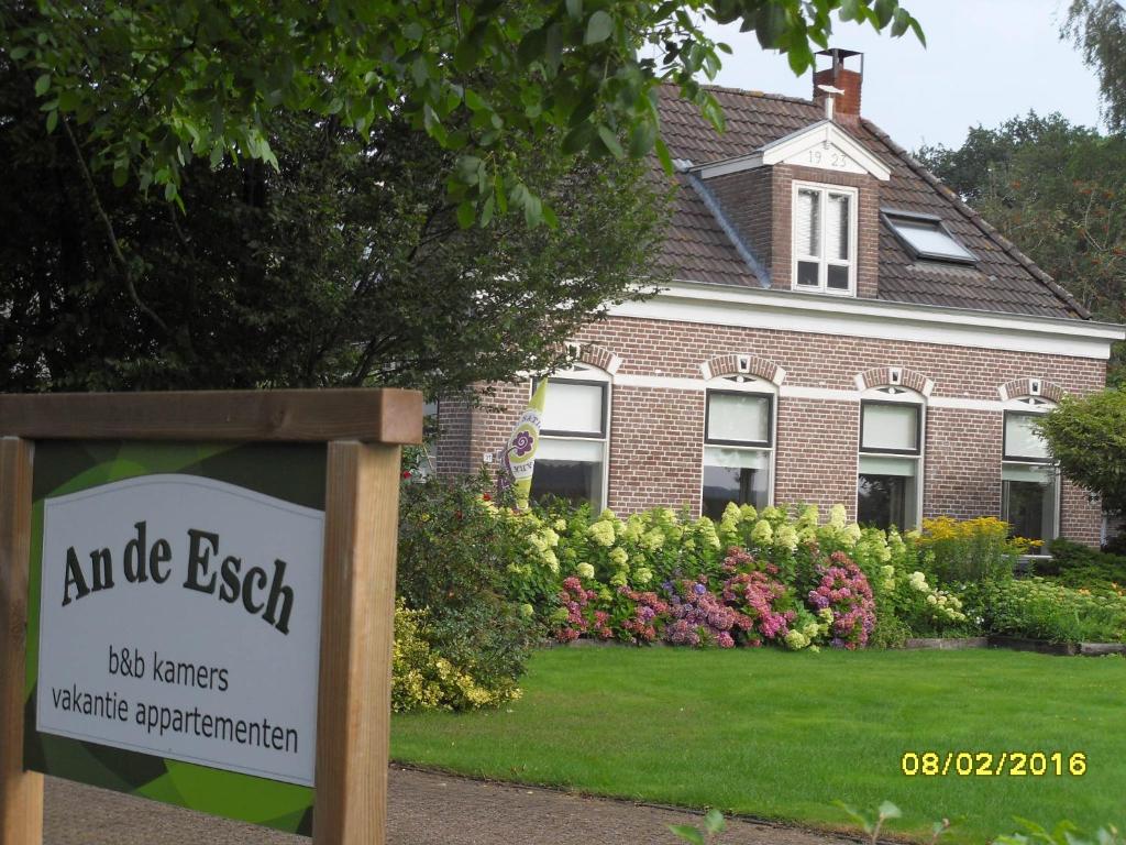 une maison avec un panneau devant une cour dans l'établissement An de Esch, à Dwingeloo