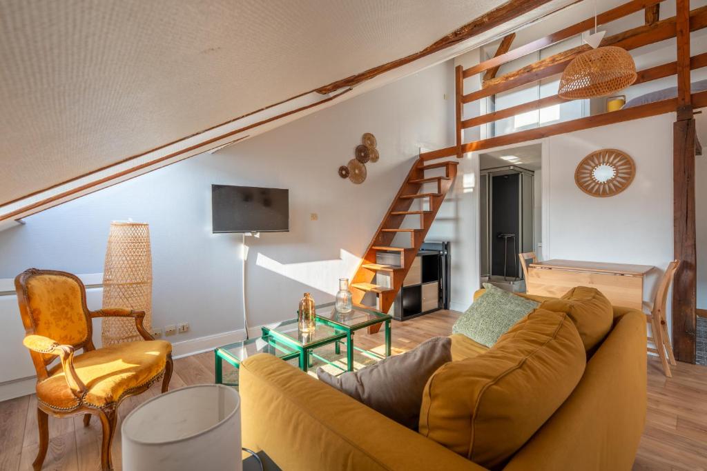 a living room with a couch and a staircase at Le cocon - Appartement en hyper centre in Blois