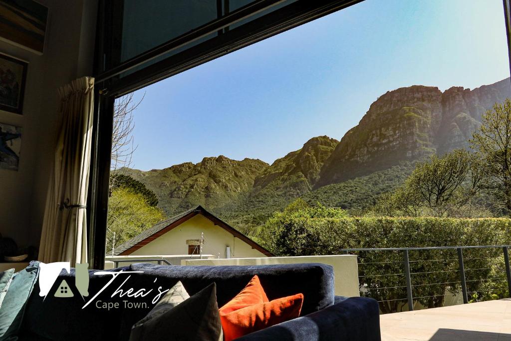 a living room with a view of mountains from a window at The Bishops Villa in Cape Town