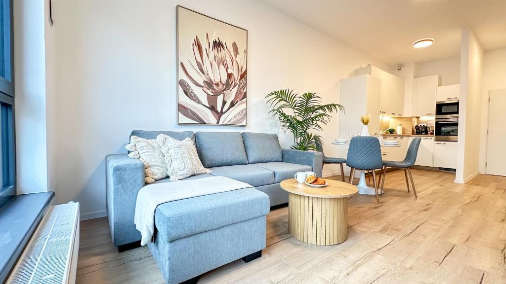 a living room with a blue couch and a table at Peony Suite Presidential Garden Free Parking in Bratislava