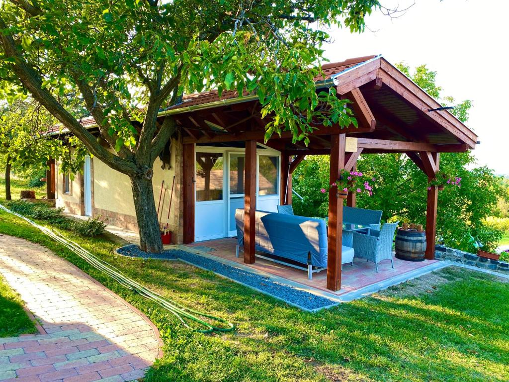 a gazebo with a couch and chairs in a yard at Badacsony Hegypanoráma Apartman in Badacsony