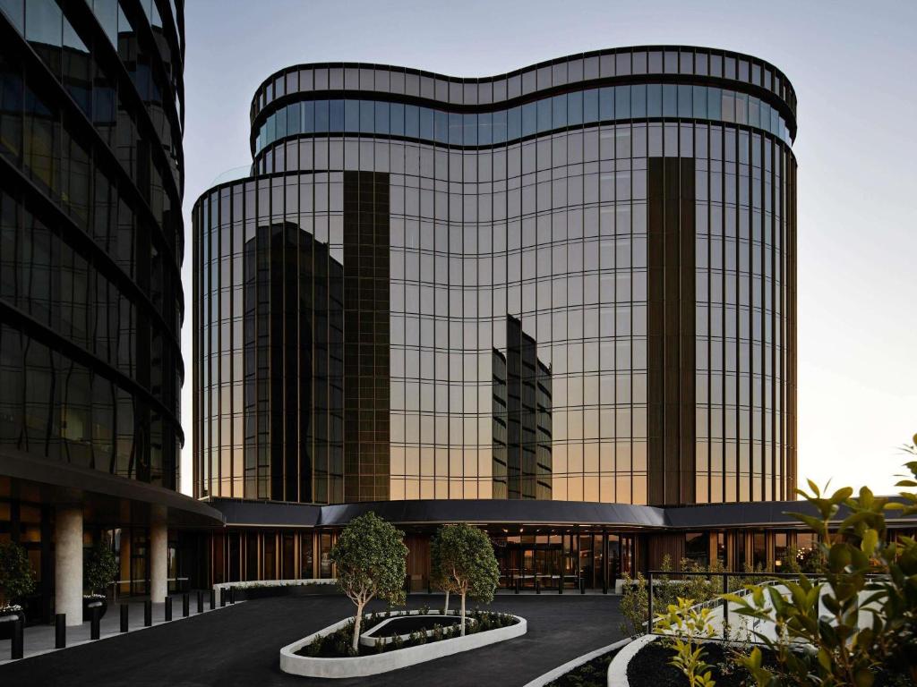a large glass building with two tall buildings at Hotel Chadstone Melbourne MGallery Collection in Chadstone