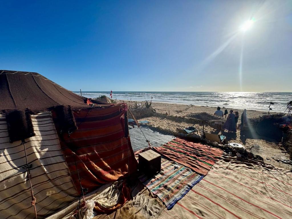 a beach with a tent and people on the beach at Sidi kawiki azro plage in Essaouira