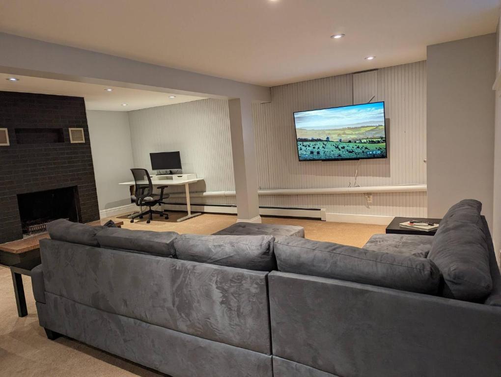 a living room with a large couch and a tv at Atlantic Oasis in Halifax