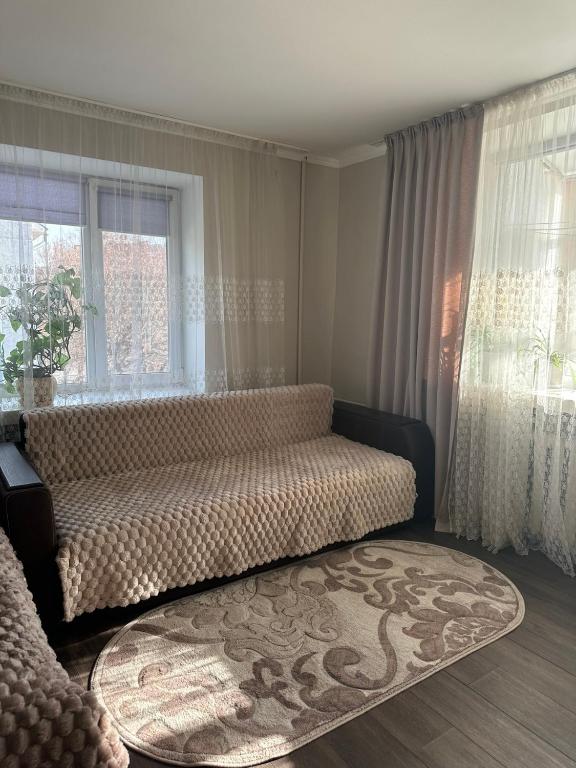 a living room with a couch and a window at Апартаменти в центрі з кондиціонером in Lutsk