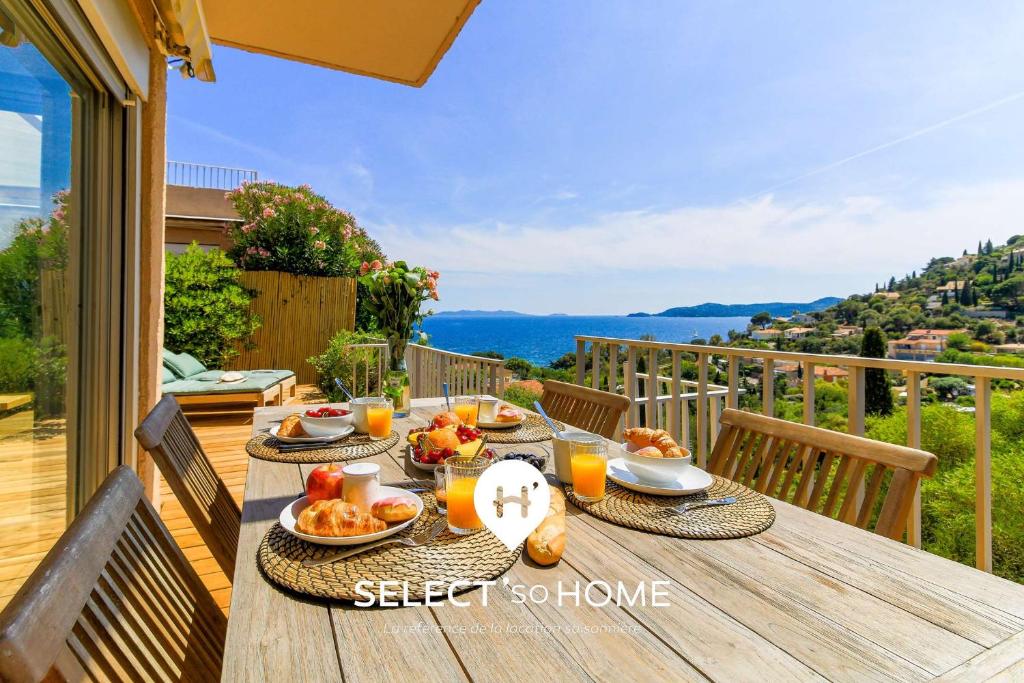 einen Holztisch mit Essen auf dem Balkon in der Unterkunft SELECT'soHOME - Splendide Mazet avec vue mer à La Fossette - SOLE&MARE in Le Lavandou