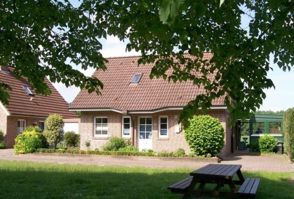 a picnic table in front of a house at Schöne Auszeit RE14 in Sögel
