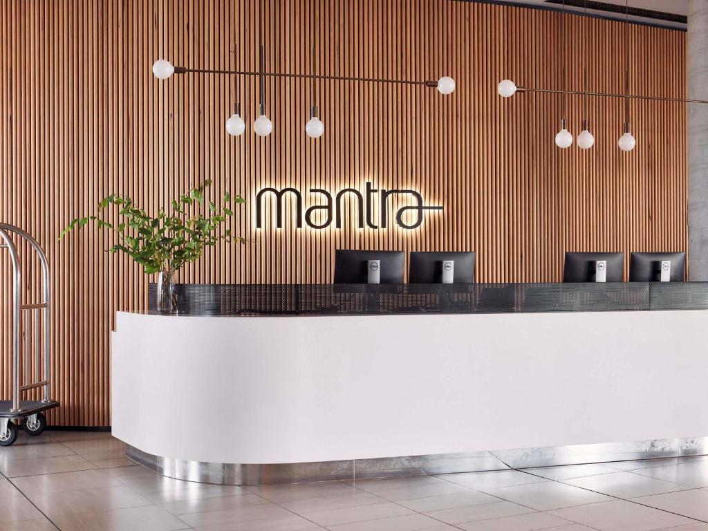 a lobby with a counter with aania sign on the wall at Mantra Melbourne Epping in Epping