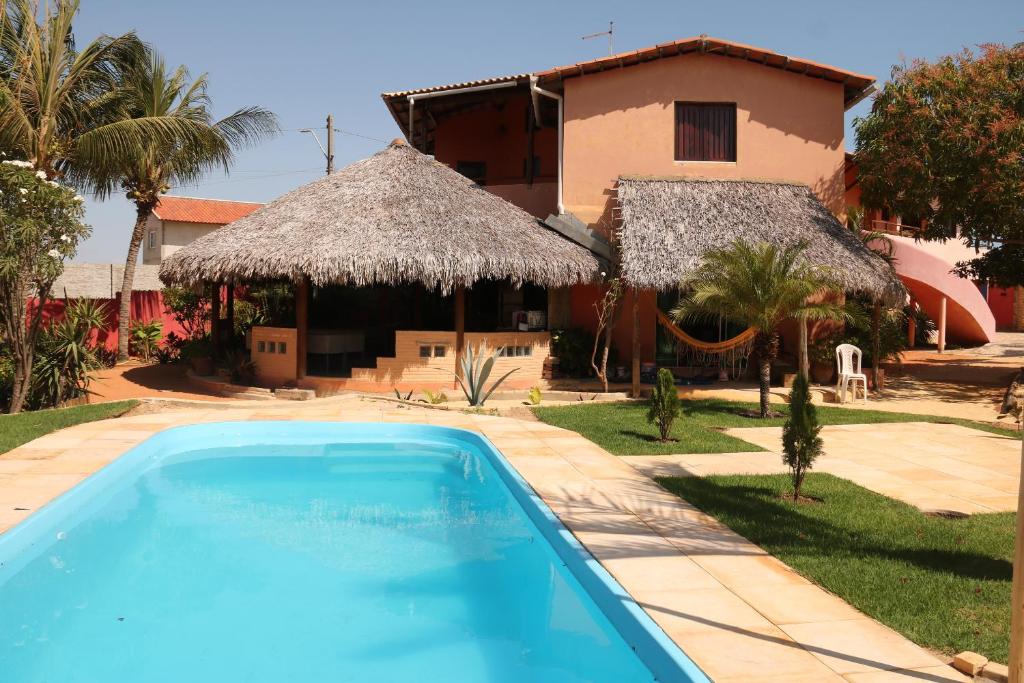 a swimming pool in front of a house at Pousada Casa do Jardim in Canoa Quebrada