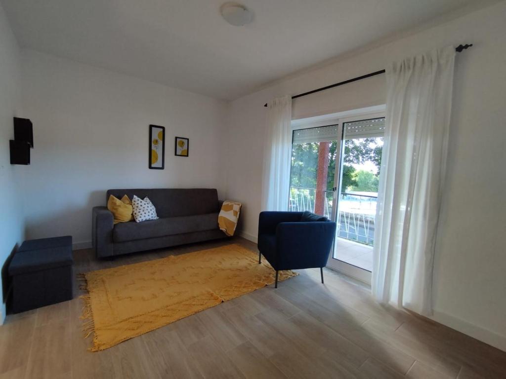 a living room with a couch and a chair at Casa da Nogueira in Paredes de Coura