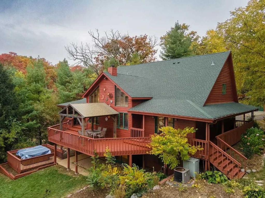 una vista aerea di una casa con un ampio ponte di Monthly or Seasonal Large Petite Lake 44 Lakehouse Retreat with Private Pier and Hot Tub secluded Deep in the Woods a Fox Lake