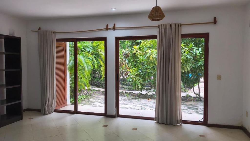 a room with sliding glass doors with a view of a yard at Selvamar 402 in Playa del Carmen