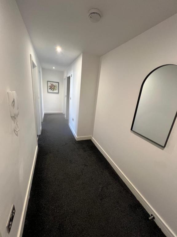 a hallway with a mirror and a phone on a wall at Bright & Spacious Apartment with large balcony and free parking in Oxford