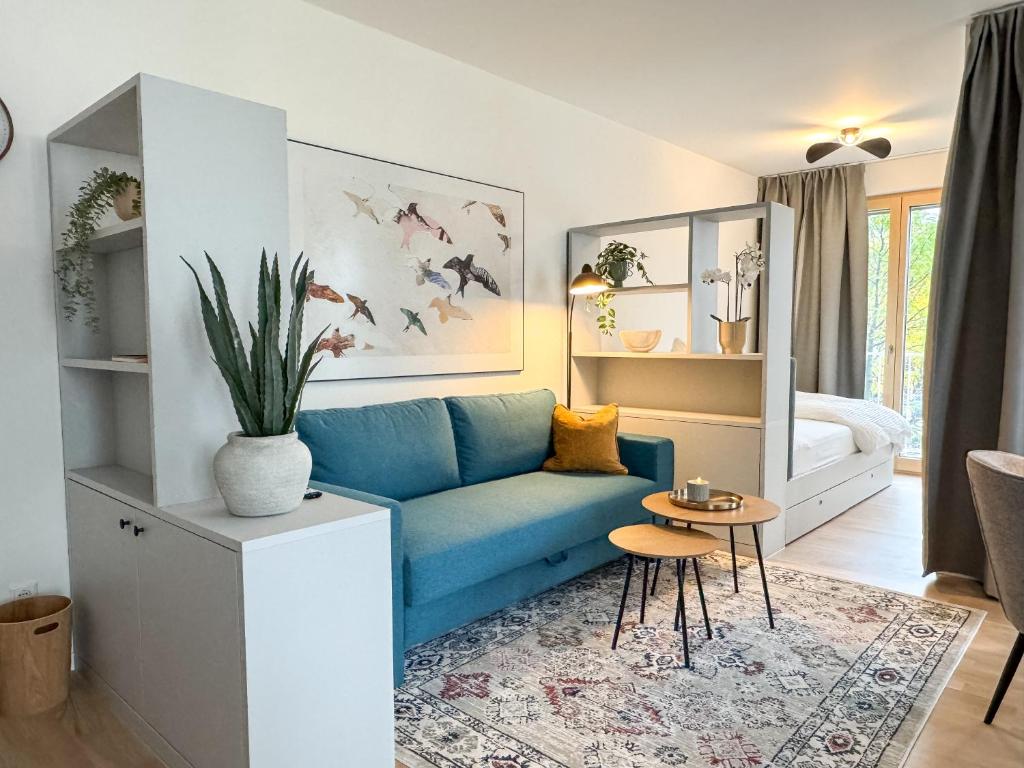a living room with a blue couch and a table at Studio Apartments Lumper Höhe in Ravensburg
