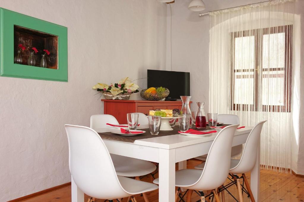 a dining room with a white table and white chairs at Holiday home Castelier in Vodnjan