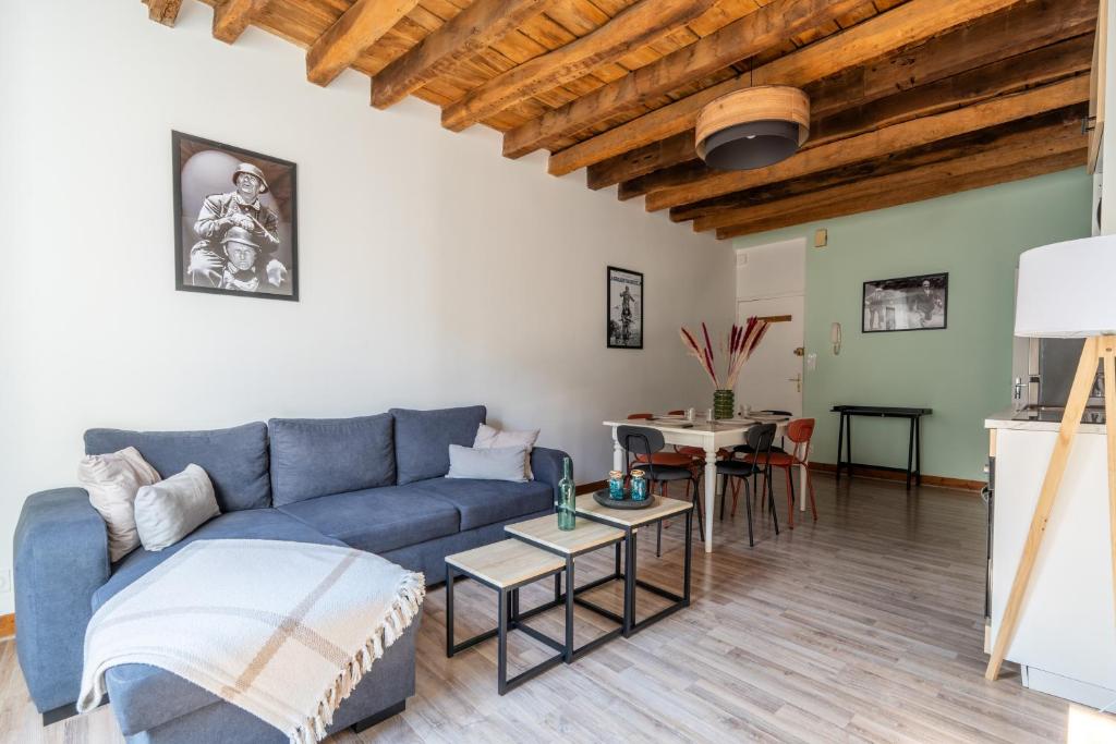 a living room with a blue couch and a table at La Grande Vadrouille - 8 personnes en hyper centre in Blois