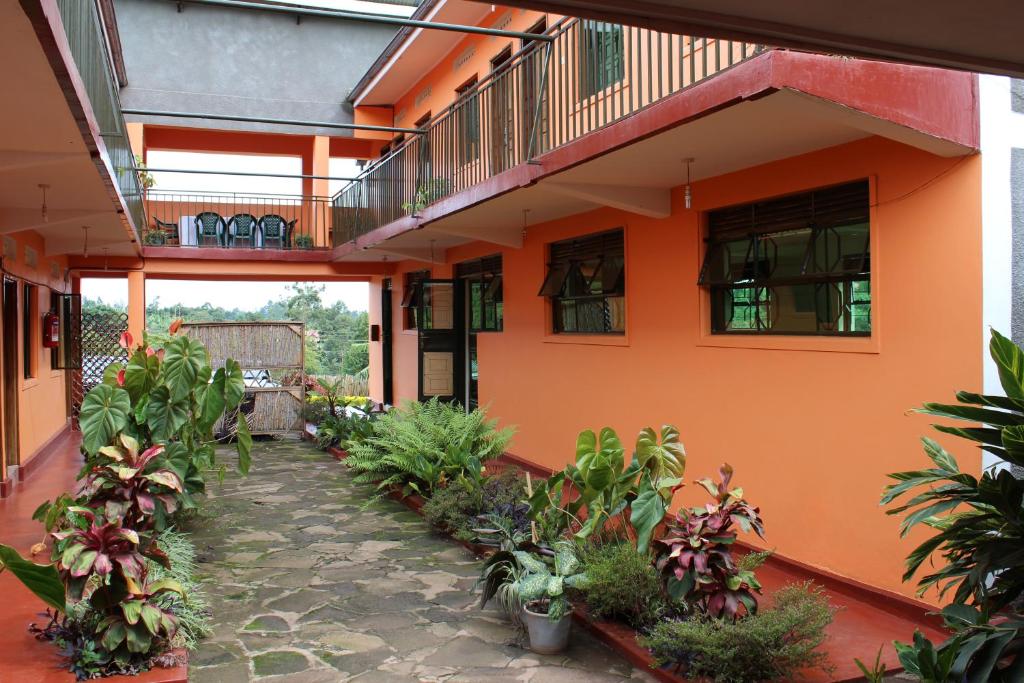 an orange building with plants in a courtyard at Westend Motel in Fort Portal