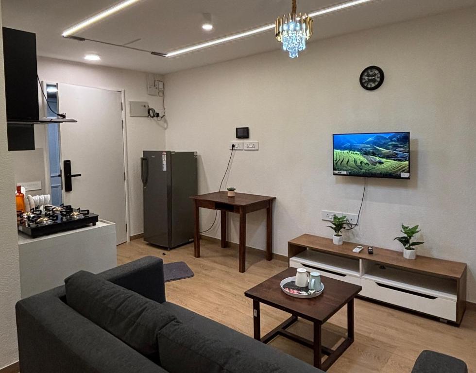 a living room with a couch and a tv on a wall at Studio at walking distance from airport in Pune